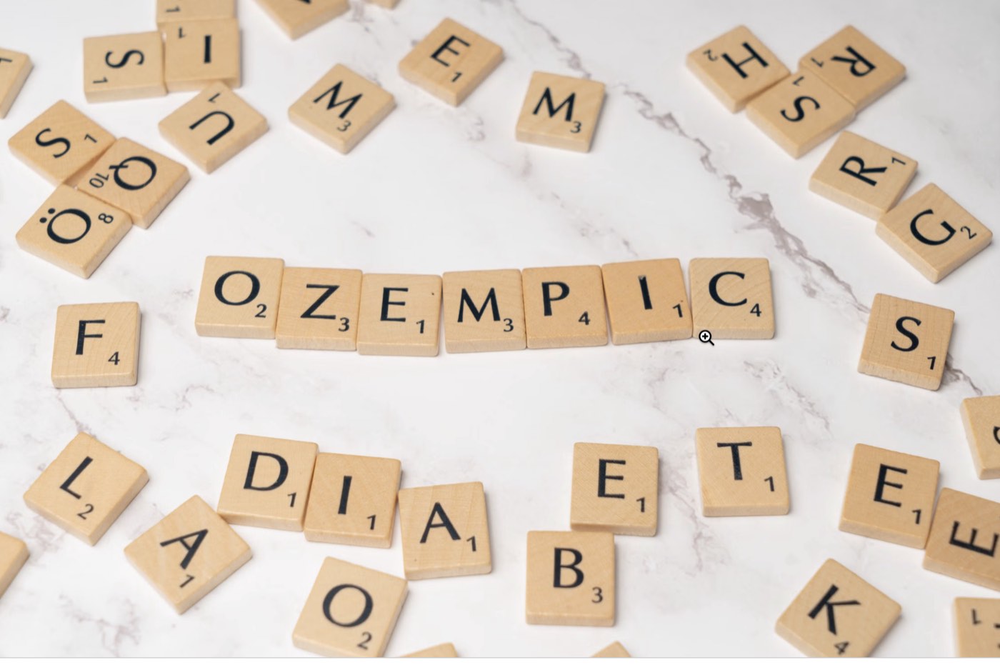 Le mot Ozempic formé avec des lettres de scrabble en bois, entouré du mot diabète